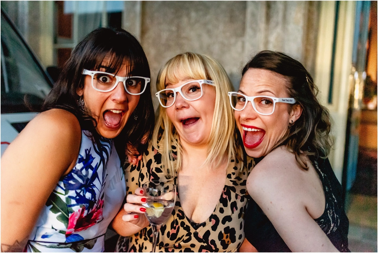 Wedding guests wear funny glasses at a wedding.
