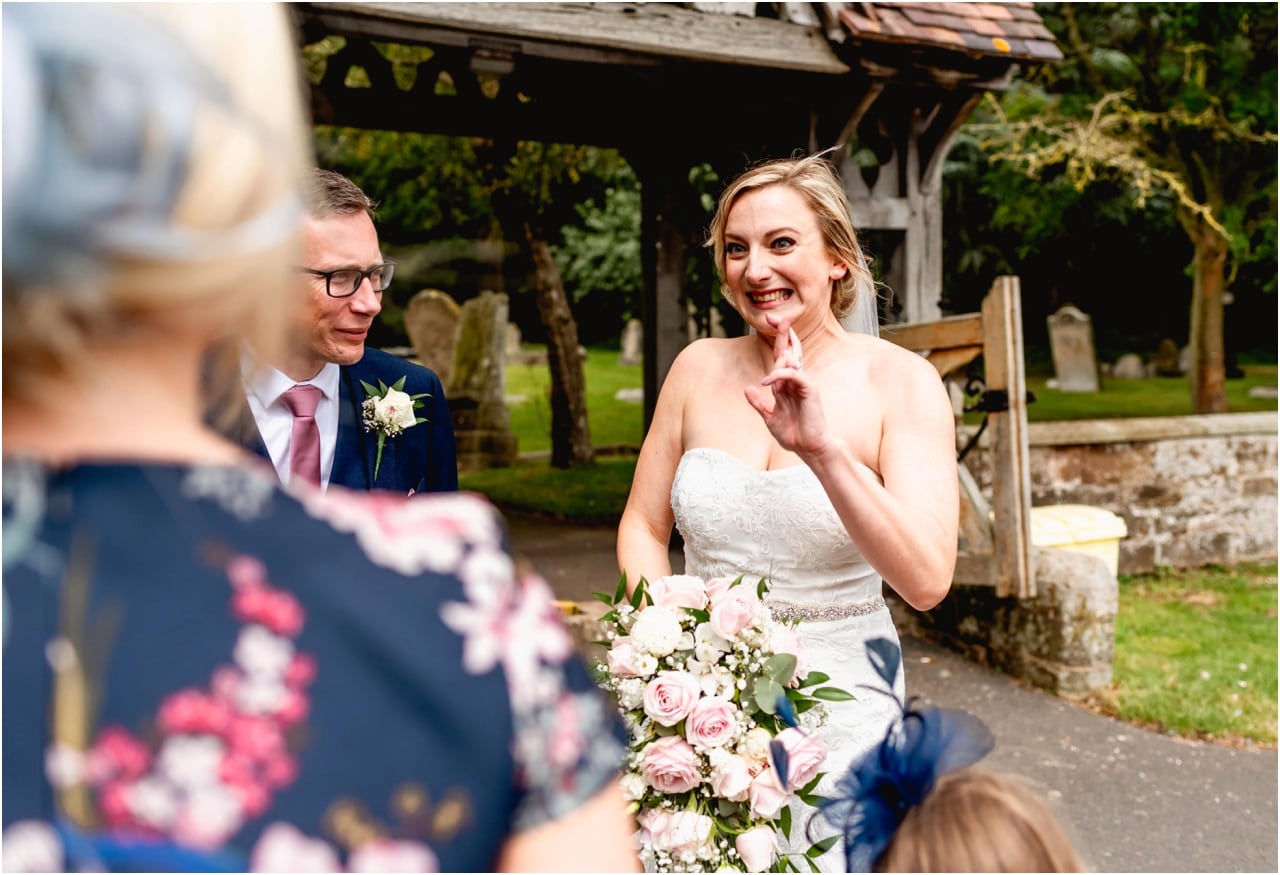Bride holds her fingers crossed before wedding ceremony outside church