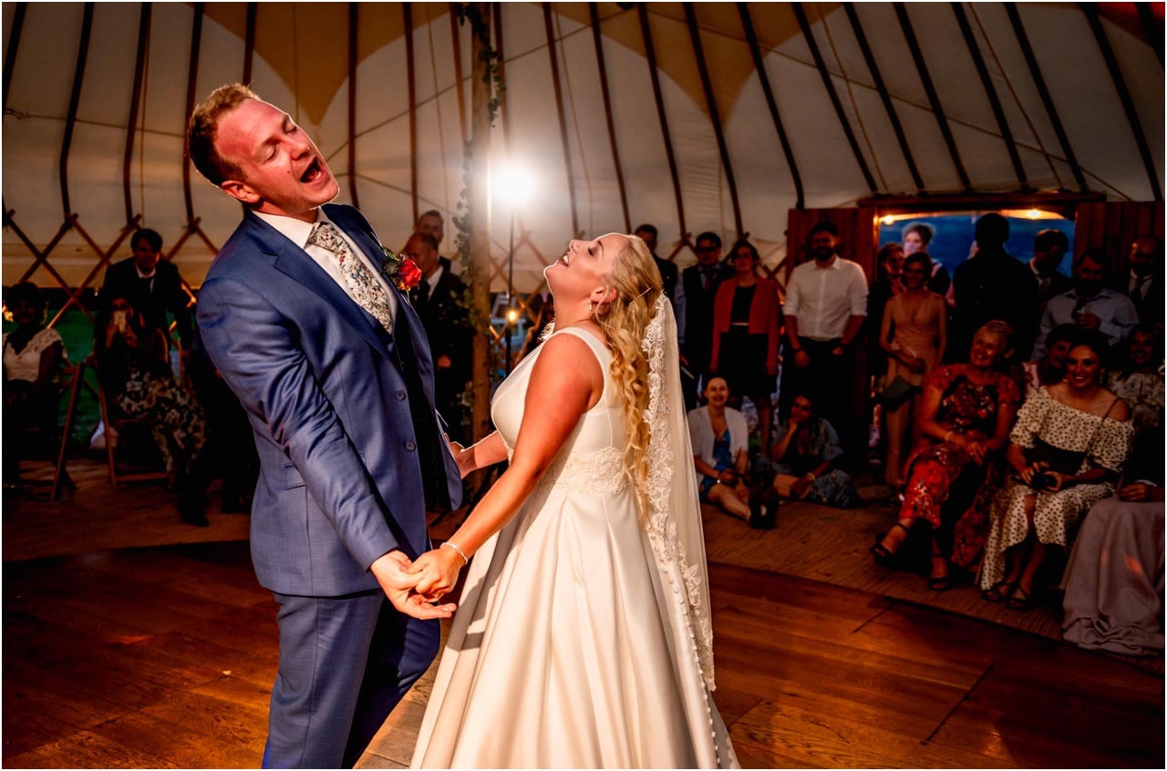 Bride and groom sing together during their first dance in a bell tent at Pennard Hill Farm in Somerset