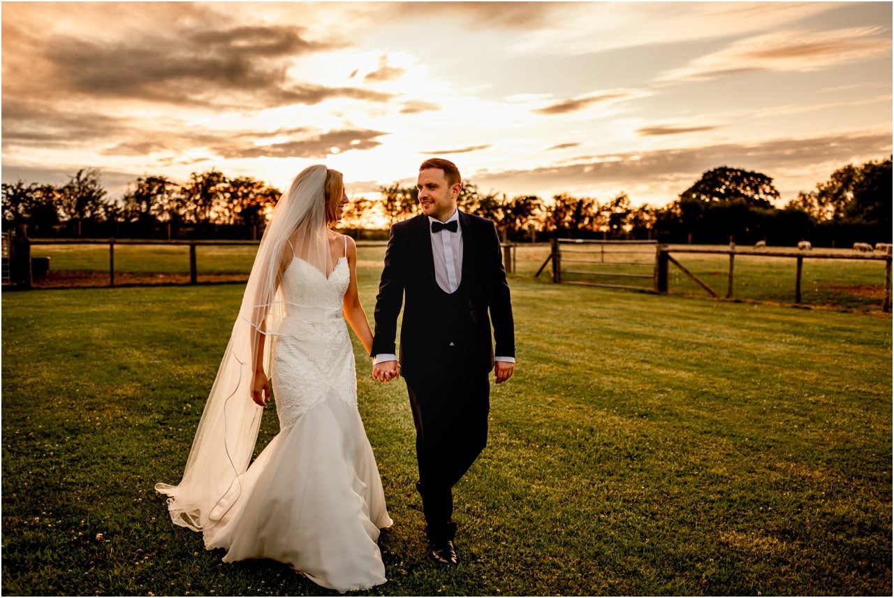 Bride and groom walking together during their wedding at golden hour before the party begins.