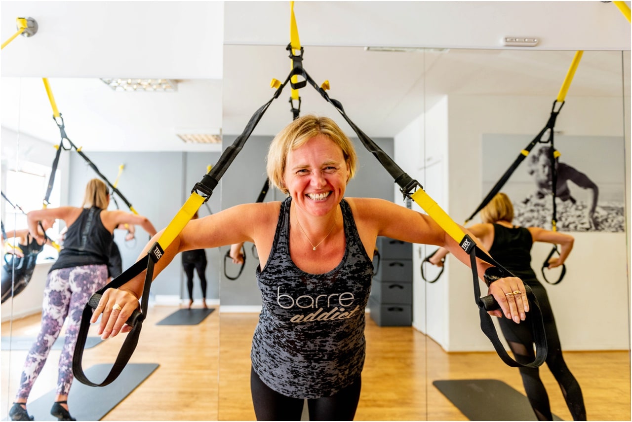 Lady laughs while enjoying her TRX class at Pilates Lounge.