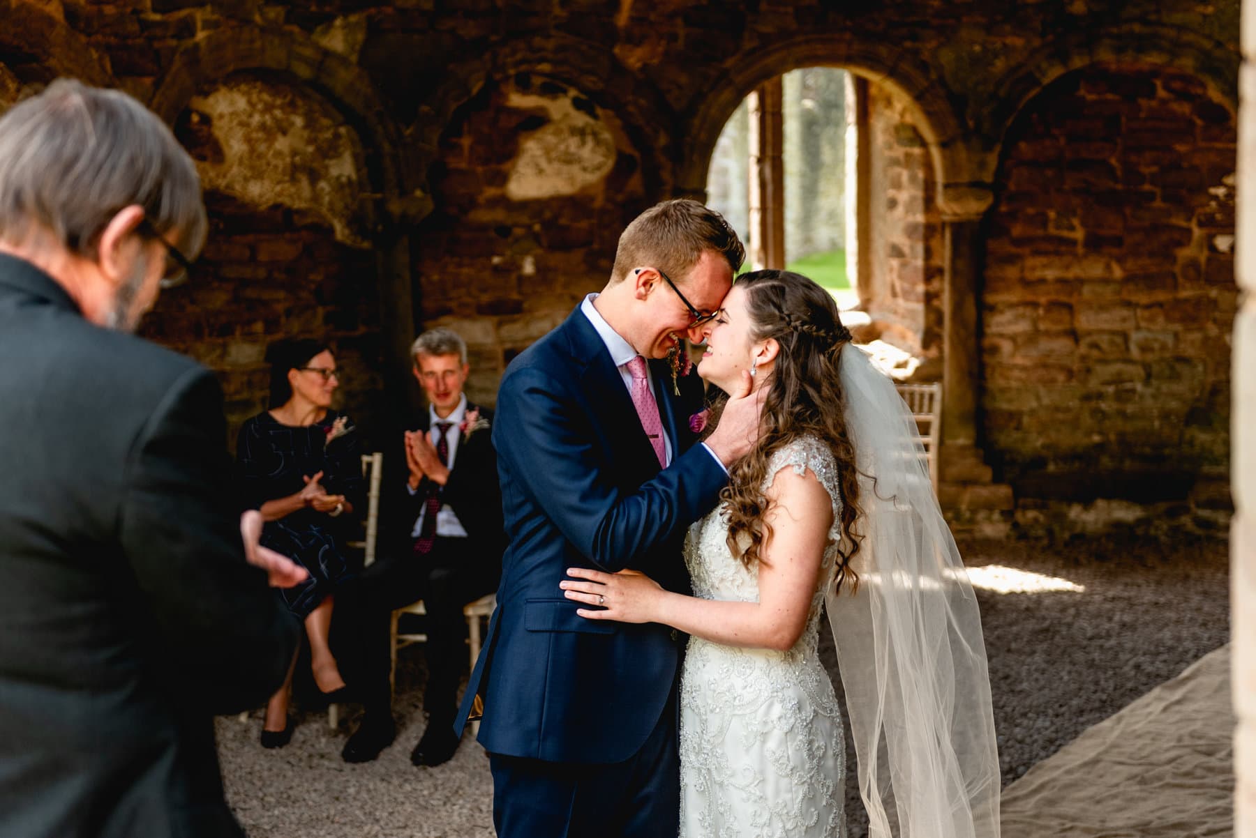 Bride and groom cuddle during their wedding ceremony at Ludlow Castle