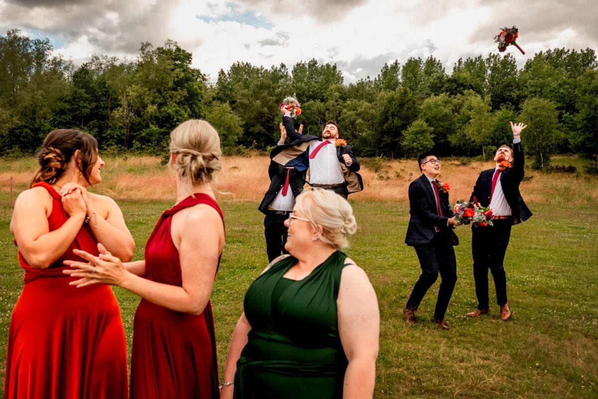men jump to catch bouquet for funny wedding photo