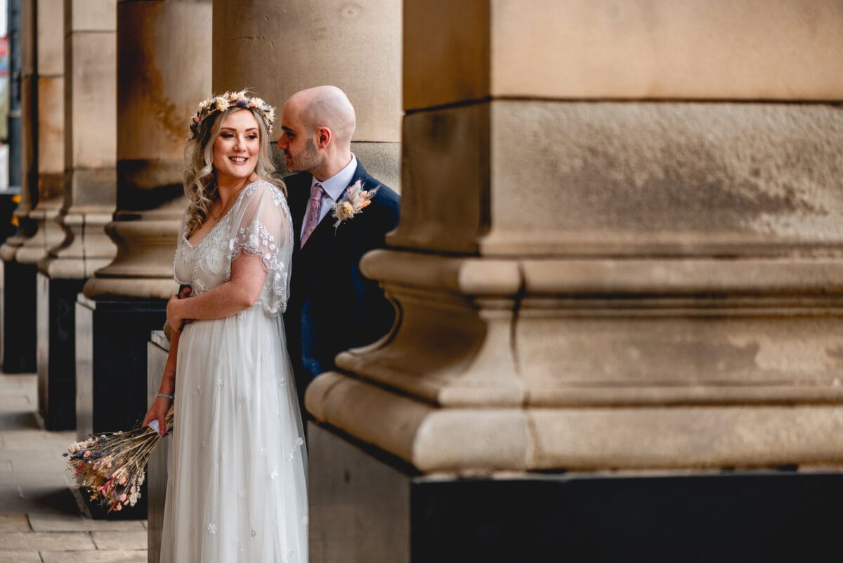 Couple celebrate their marriage in Birmingham by the pillars of the town hall