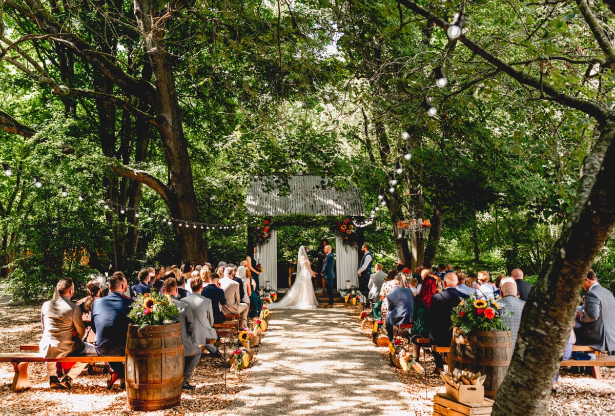 Outdoor wedding ceremony in the forest with Tania and Ryan getting married amidst lanterns and fairy lights