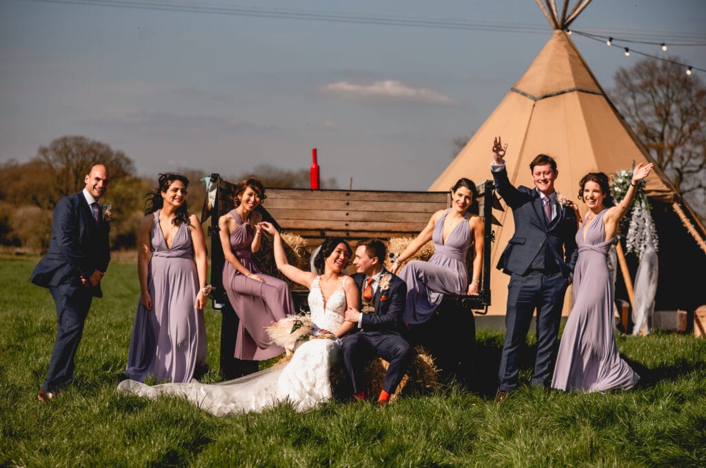Bridal party portrait on the back of a tractor in a field
