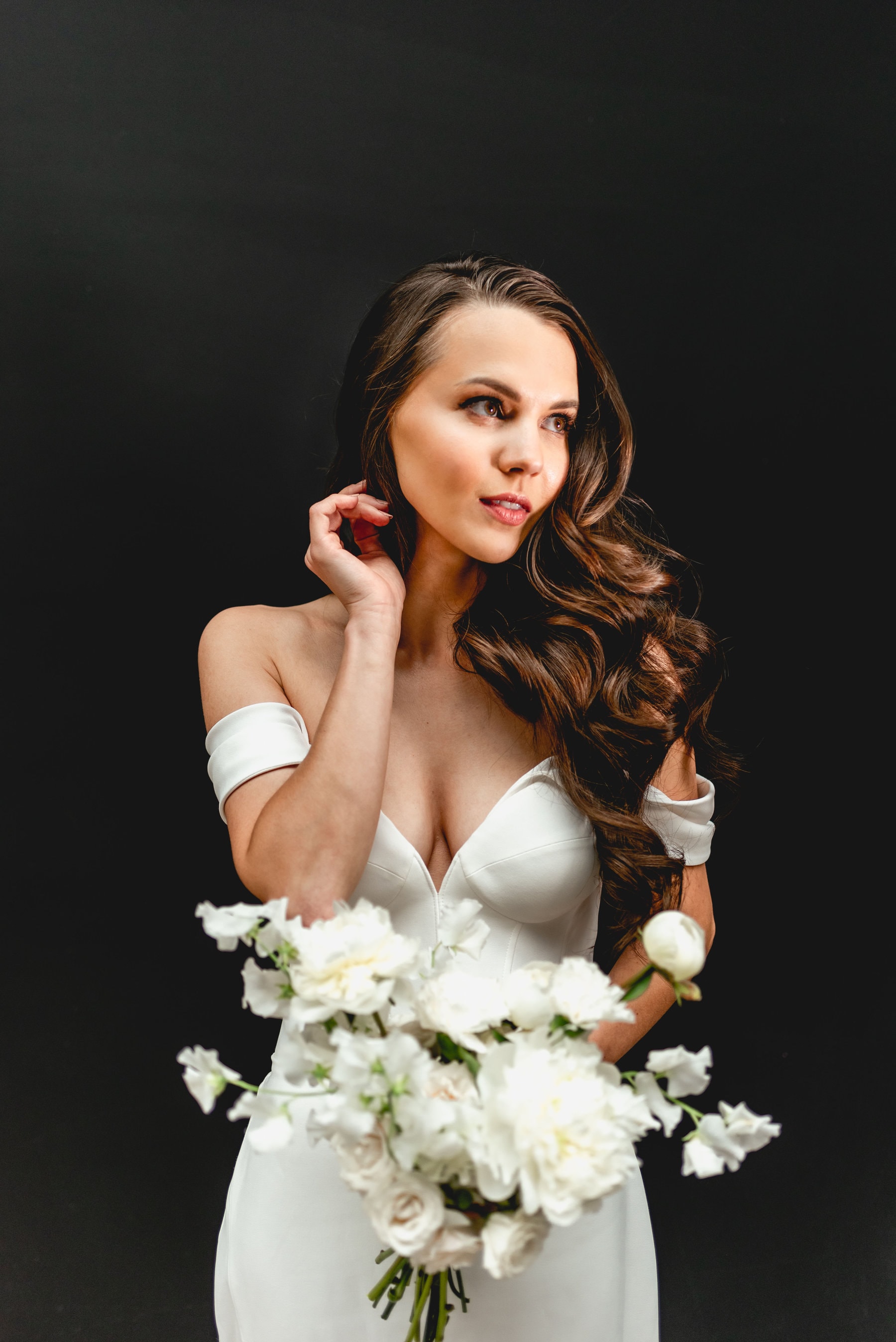 Bride wears Suzanne Neville wedding dress against black backdrop from The Wedding Club at The Bond Company