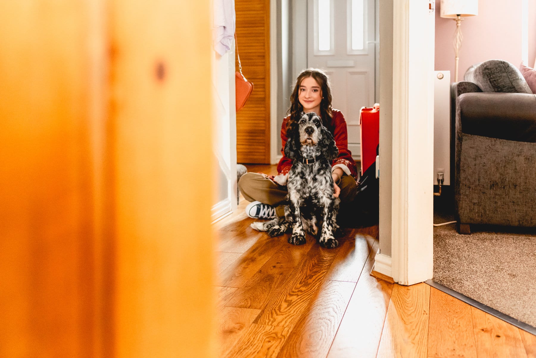 Bridesmaid sits with dog during bridal preparation