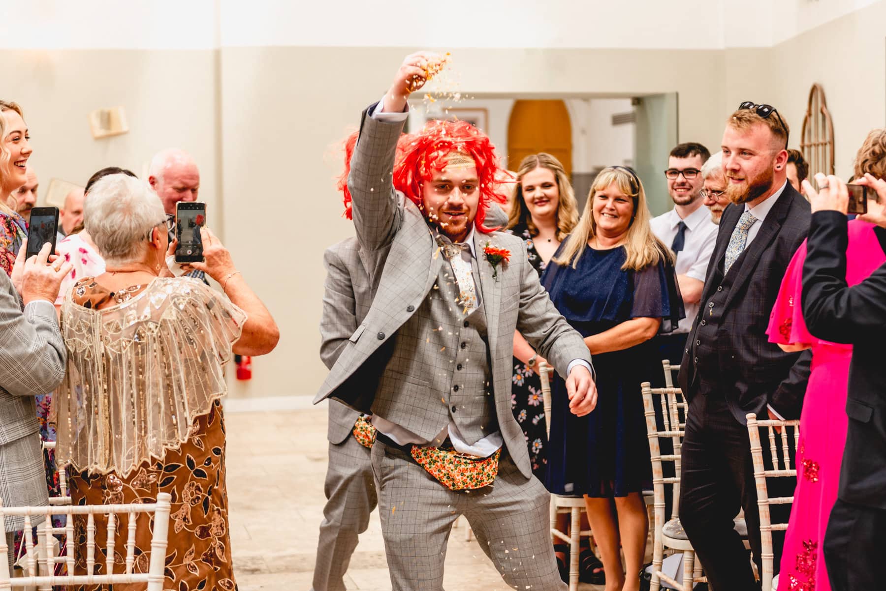 Flower men spray petals in the aisle from bumbags as they walk down the aisle at Fazeley Studios