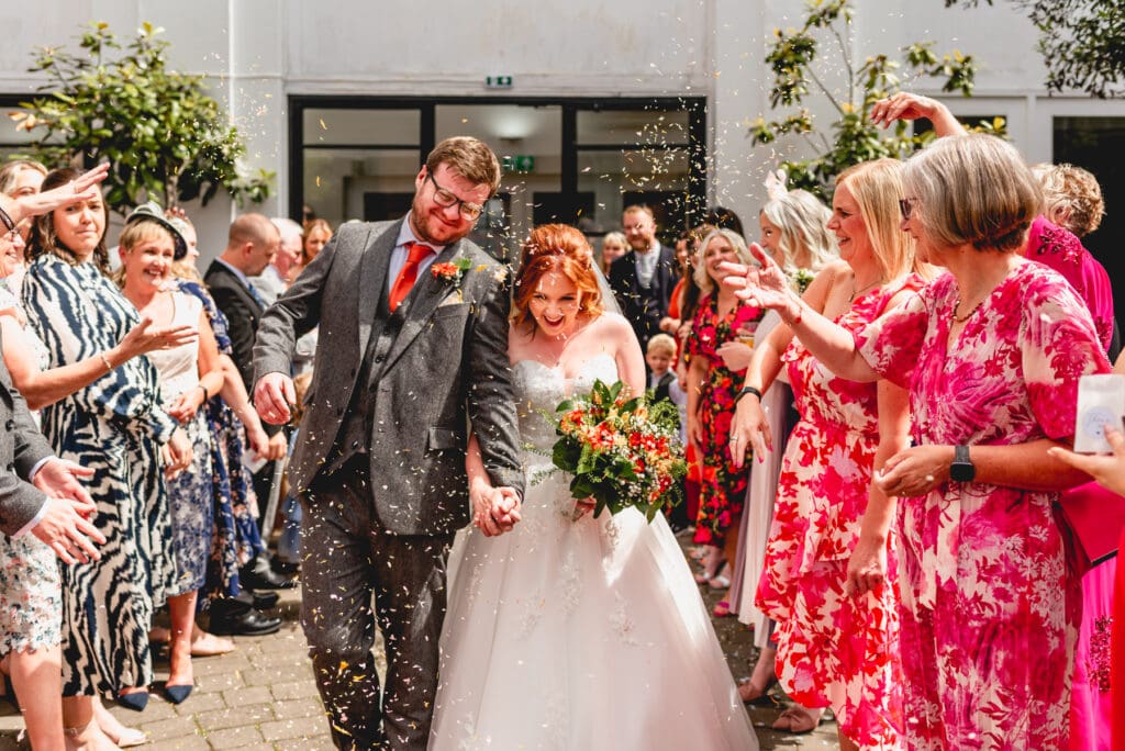 Confetti tunnel with couple in the summer courtyard
