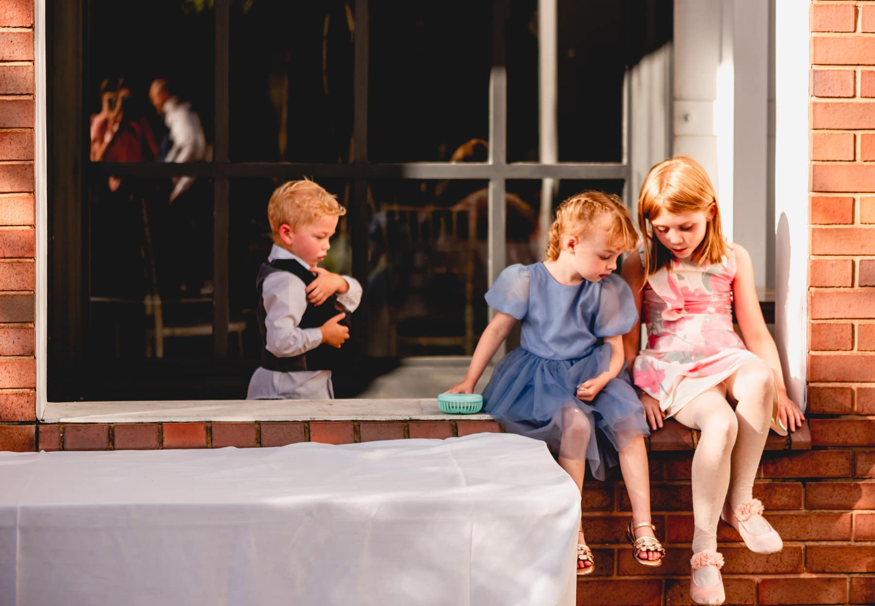 children at a wedding in the courtyard soaking up the sun