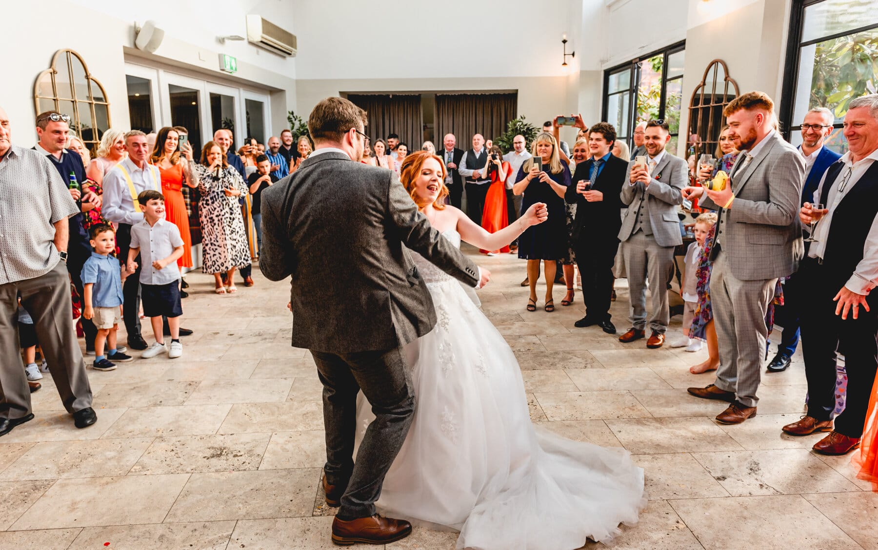 Man and woman perform their first dance to their wedding guests