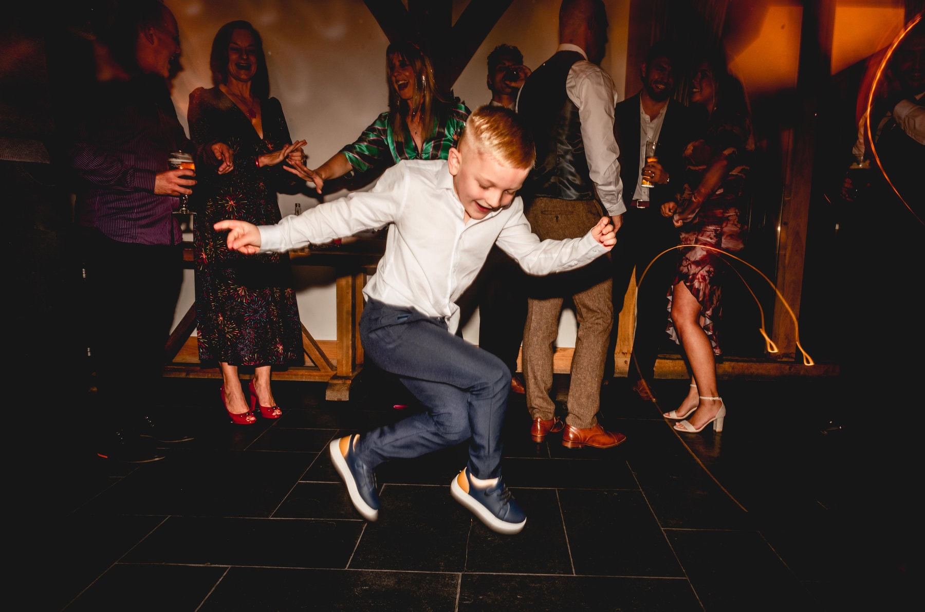 young boy jumps in the air on dancefloor at Mythe Barn during wedding reception