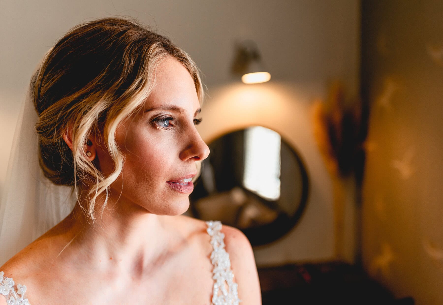 Portrait of a bride before her wedding day, her blonde hair is tied up and her wedding dress is on