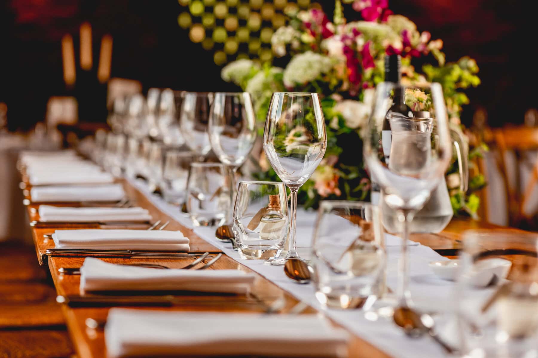 Wine glasses lined up on the table at a wedding at Swallows Nest Barn