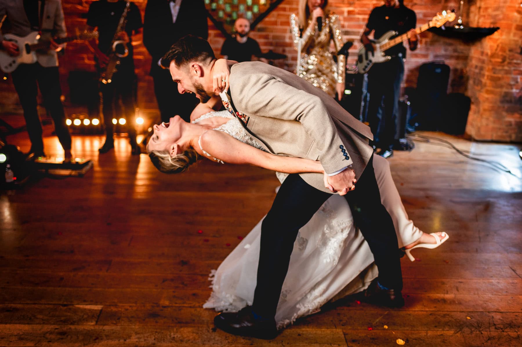 Groom dips bride during first dance with Apollo Gold Band at Swallows Nest Barn