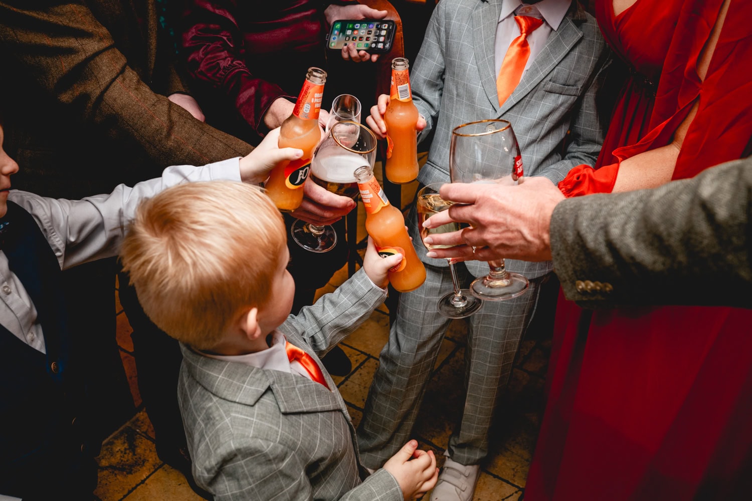 Children and adults touch classes to cheers a happy couple