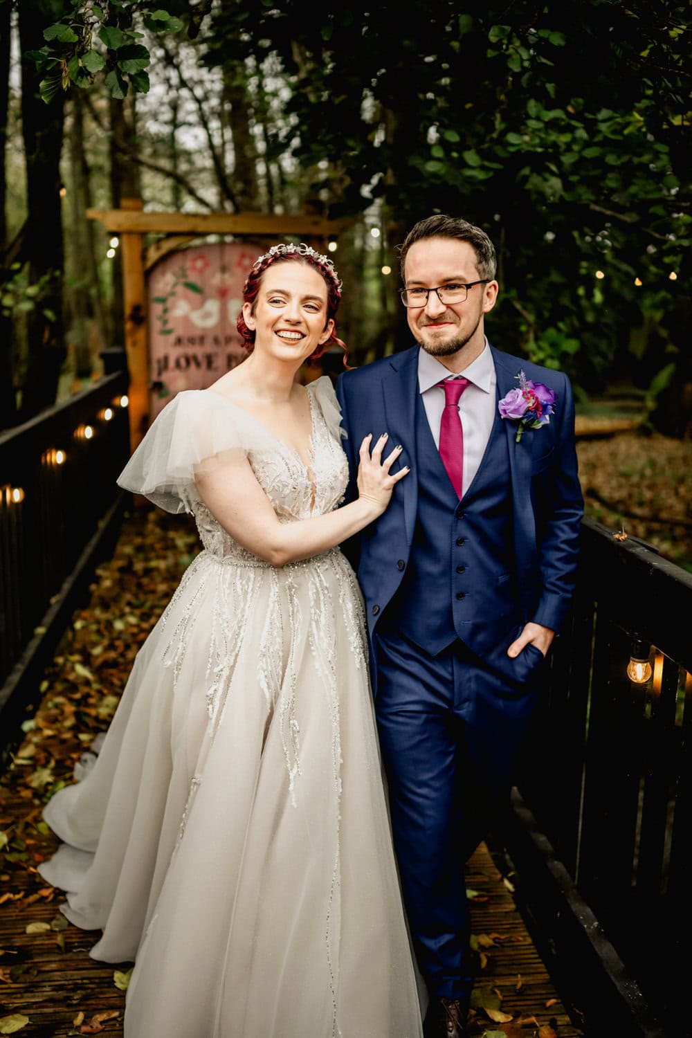 Blackbrook Barns wedding couple on bridge after first look in wedding dress and blue suit with pink tie