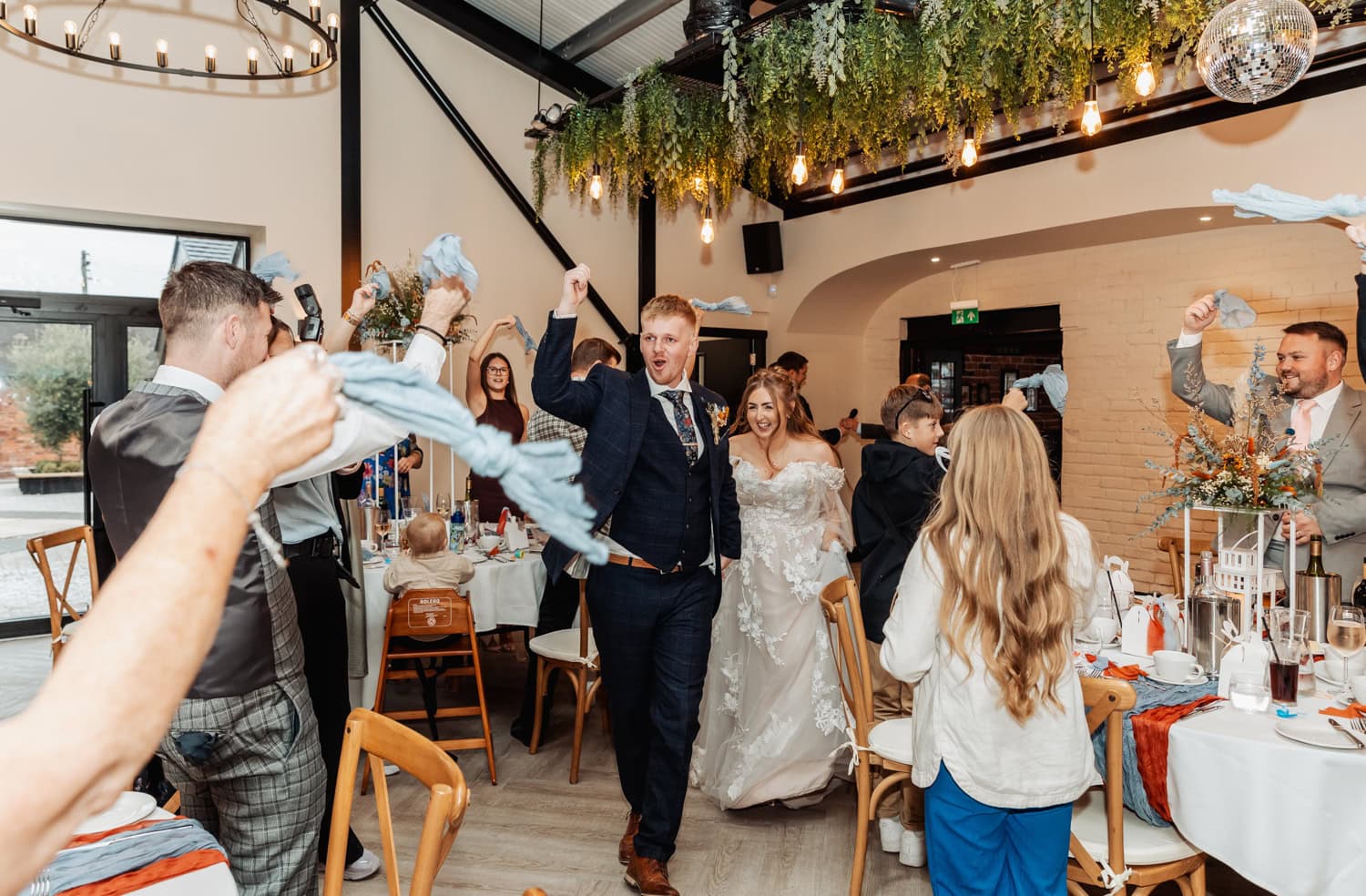 Bride and groom enter the wedding reception with fists in the air at their Blackbrook Barns Wedding