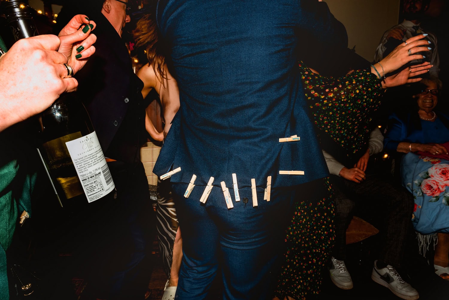 The peg game at a wedding at Hargate Hall, groom shot from behind showing pegs stuck to the hem of his suit jacket during a game.